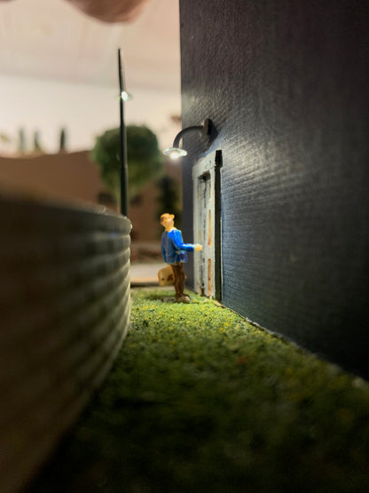 Man knocking on door lit by Industrial Building lamp